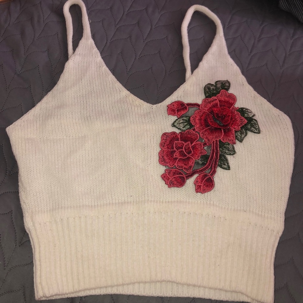 This is a cute white top with a flower embroidery!